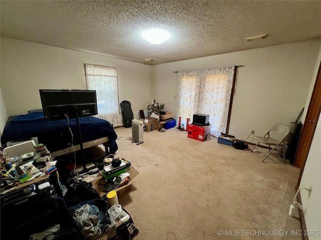 bedroom featuring carpet flooring and a textured ceiling