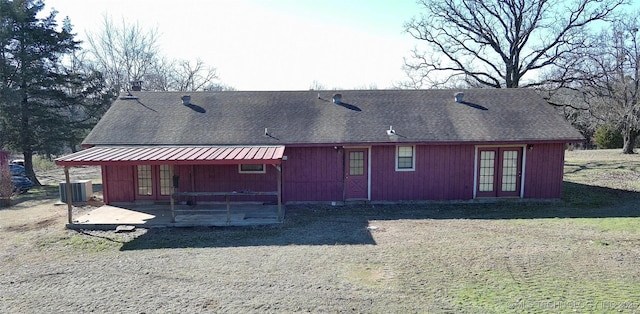 back of property with central AC and a patio area