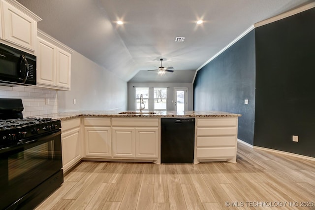 kitchen featuring white cabinets, sink, lofted ceiling, and black appliances