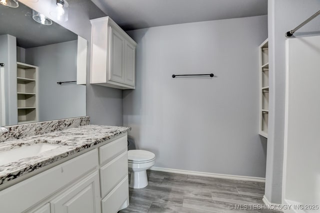 bathroom with hardwood / wood-style floors, vanity, and toilet