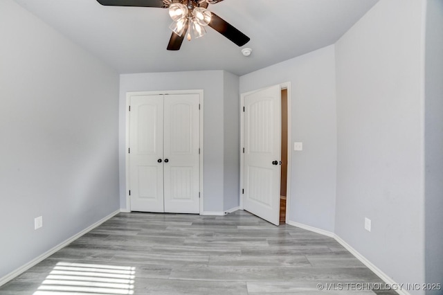 unfurnished bedroom featuring ceiling fan, a closet, and light hardwood / wood-style floors