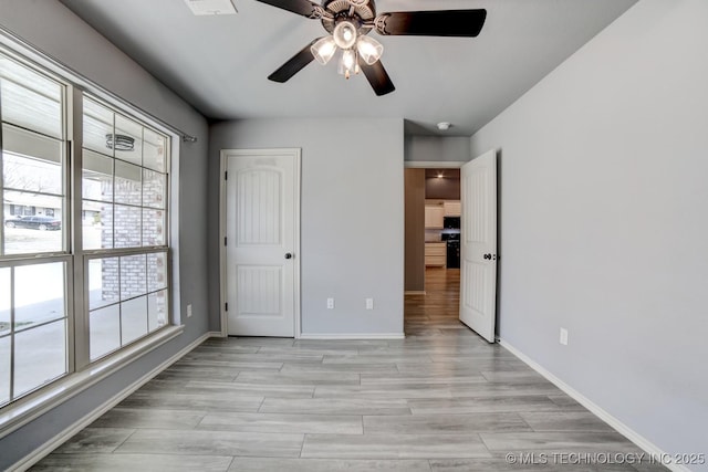 unfurnished bedroom featuring multiple windows and ceiling fan