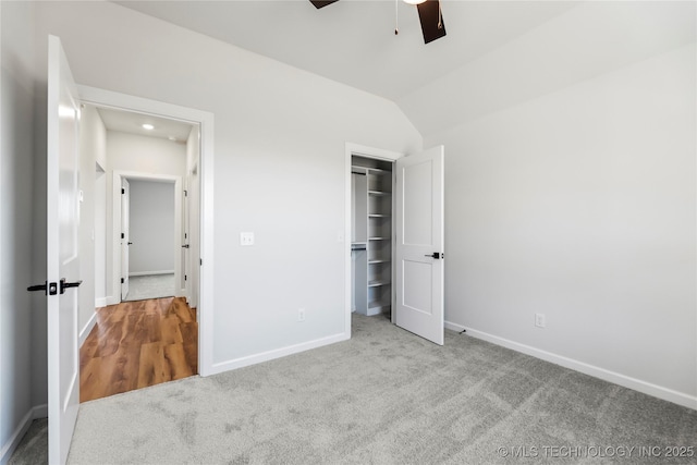 unfurnished bedroom with a closet, ceiling fan, lofted ceiling, and light colored carpet