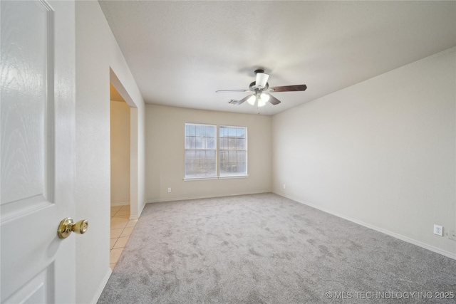 carpeted spare room with ceiling fan