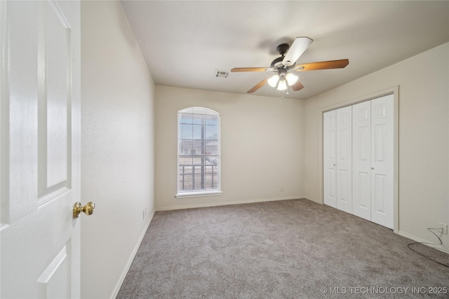 unfurnished bedroom featuring carpet, ceiling fan, and a closet