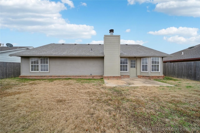 back of property with a lawn and a patio