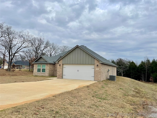 view of front of house featuring central AC, a garage, and a front lawn