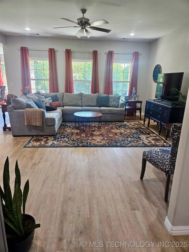 living room featuring ceiling fan and light hardwood / wood-style flooring