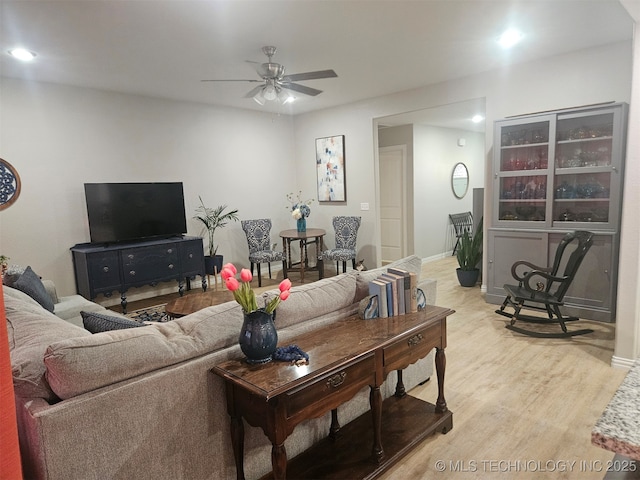 living room featuring light hardwood / wood-style floors and ceiling fan