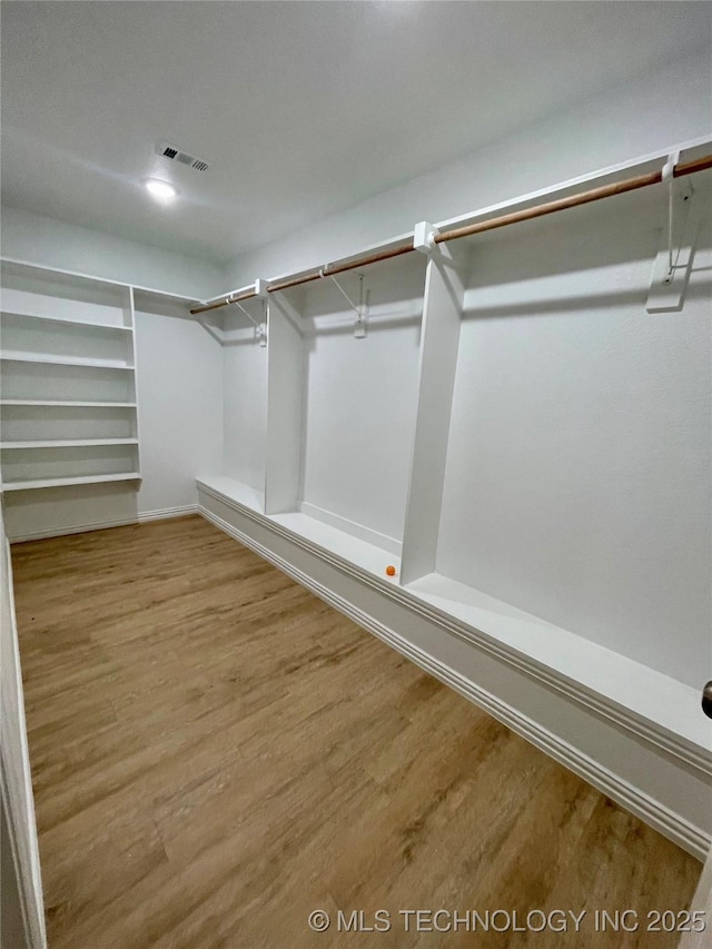 spacious closet with hardwood / wood-style floors