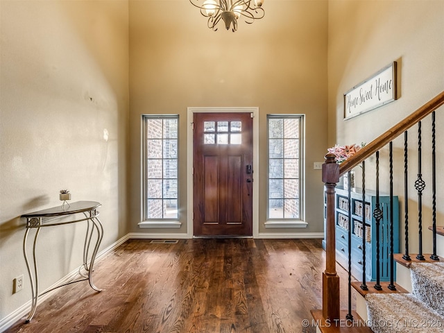 foyer featuring dark hardwood / wood-style floors, a high ceiling, and a chandelier