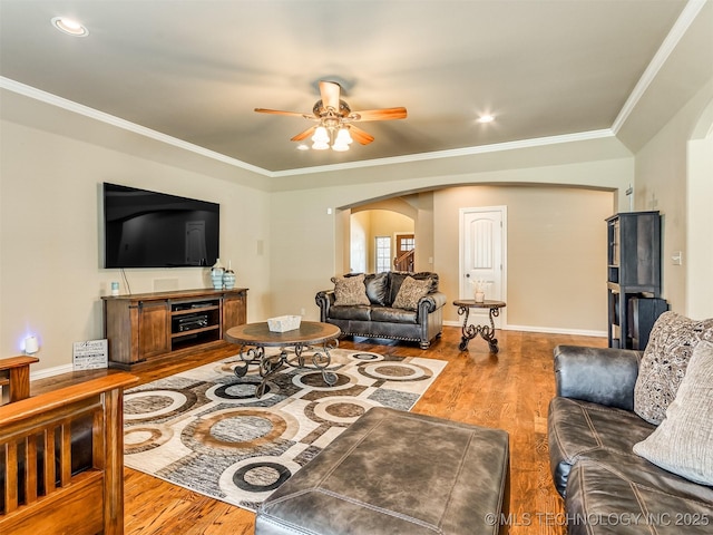 living room featuring ceiling fan, ornamental molding, and hardwood / wood-style flooring