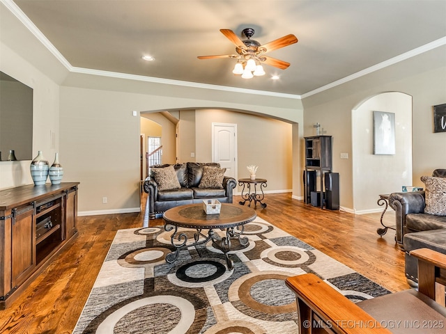 living room with dark hardwood / wood-style floors, ceiling fan, and crown molding