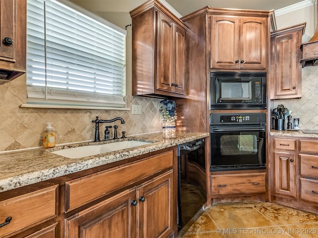 kitchen with decorative backsplash, light stone counters, sink, and black appliances