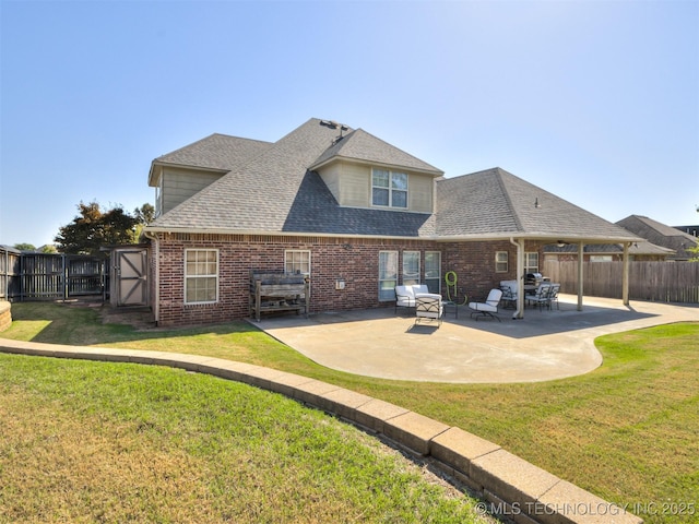 rear view of house with a lawn and a patio area