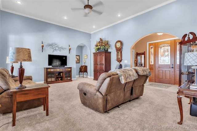 carpeted living room with ceiling fan and crown molding