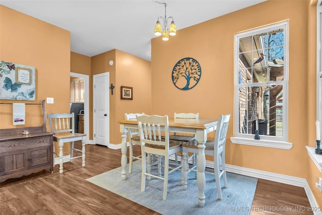 dining space featuring wood-type flooring and a notable chandelier