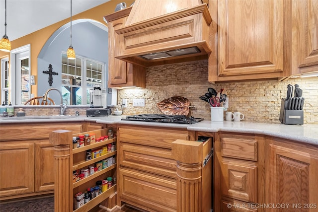 kitchen featuring decorative backsplash, sink, hanging light fixtures, and custom exhaust hood