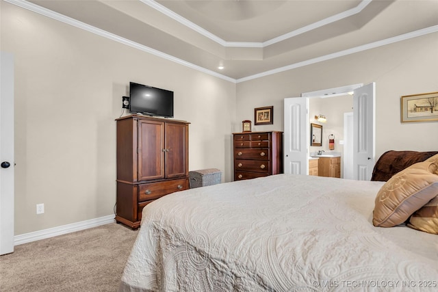 carpeted bedroom with a raised ceiling, crown molding, and connected bathroom