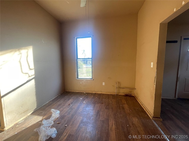 unfurnished room featuring dark wood-type flooring and lofted ceiling