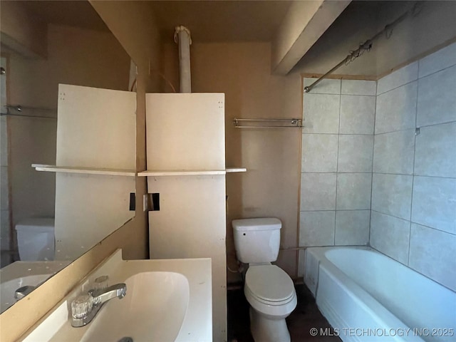 full bathroom with tiled shower / bath combo, toilet, and sink