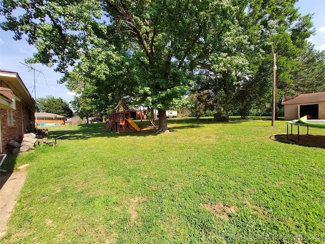 view of yard featuring a playground and a trampoline