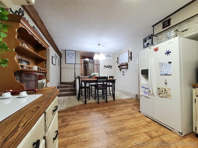 kitchen with white fridge with ice dispenser, a textured ceiling, butcher block countertops, decorative light fixtures, and a chandelier