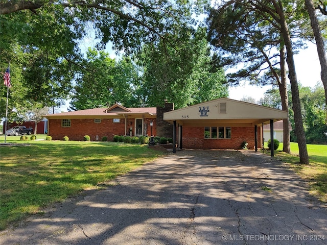 ranch-style house featuring a carport and a front lawn