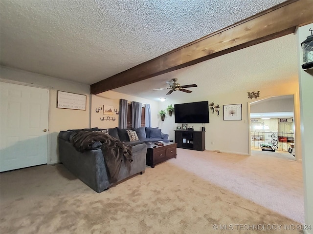 carpeted living room featuring beam ceiling, ceiling fan, and a textured ceiling