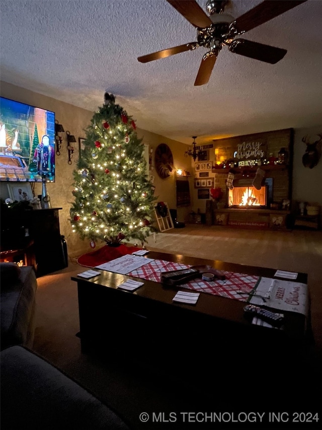 living room with a fireplace, a textured ceiling, carpet floors, and ceiling fan