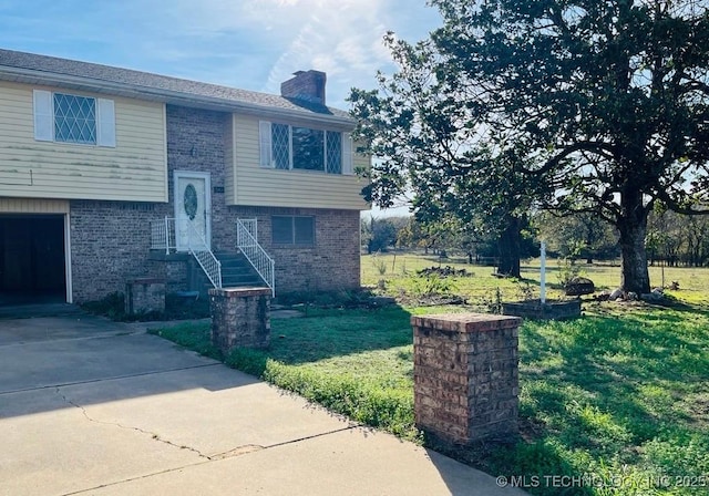 split foyer home featuring a front lawn and a garage