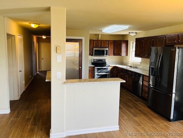 kitchen with dark brown cabinetry, stainless steel appliances, and sink