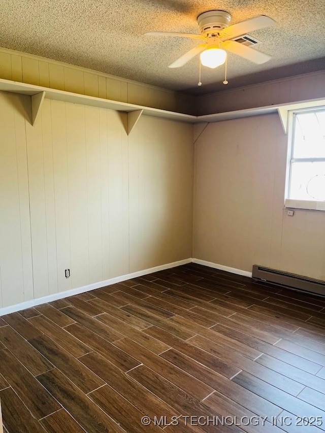 spare room featuring a textured ceiling, ceiling fan, dark wood-type flooring, and a baseboard radiator