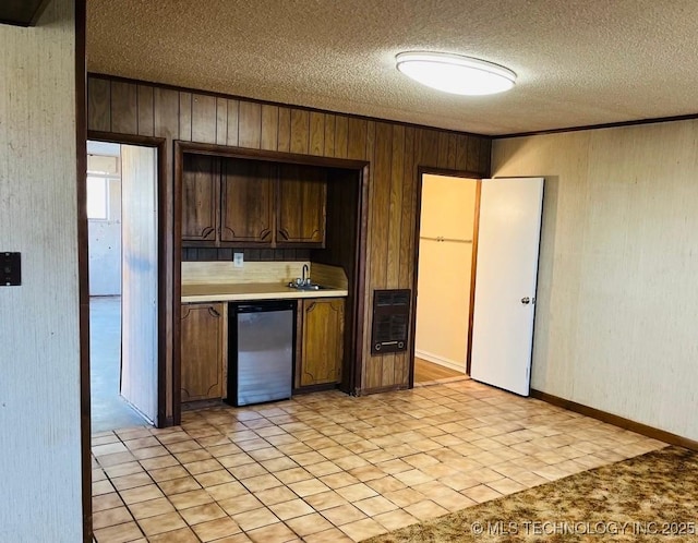 kitchen with dark brown cabinets, a textured ceiling, fridge, and sink