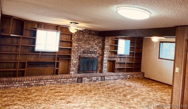 unfurnished living room featuring a textured ceiling, carpet floors, a brick fireplace, and ceiling fan