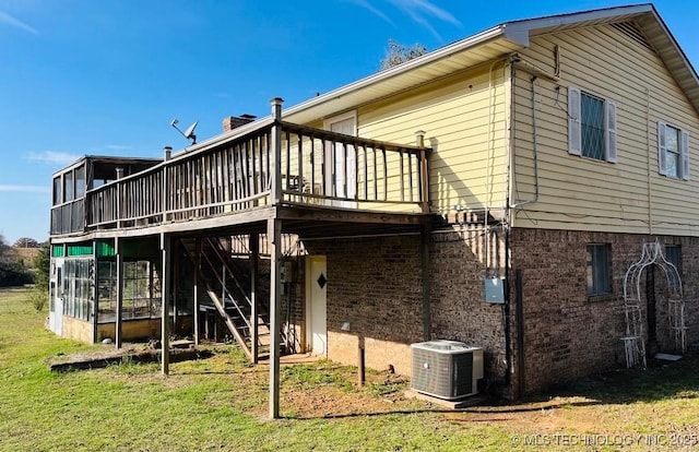 back of house with a lawn, a sunroom, cooling unit, and a deck