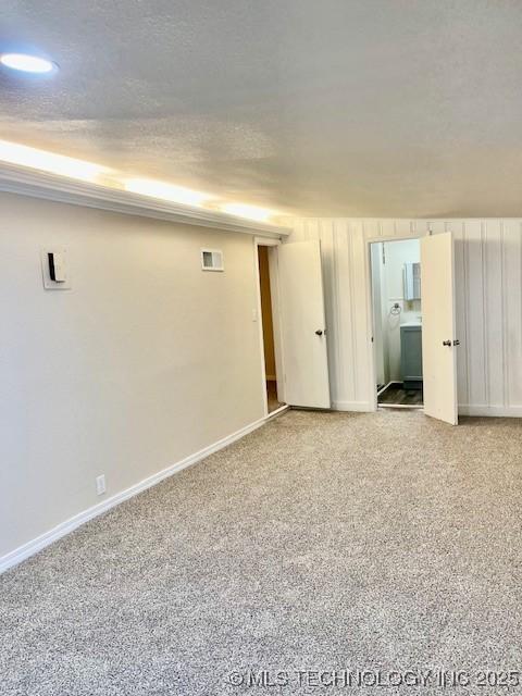 empty room with light colored carpet and a textured ceiling