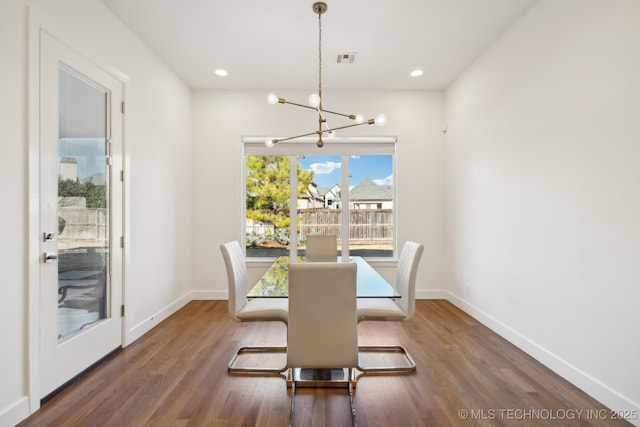 dining space featuring dark hardwood / wood-style floors and a notable chandelier