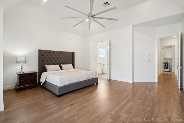 bedroom featuring washer / clothes dryer, wood-type flooring, ensuite bathroom, and ceiling fan