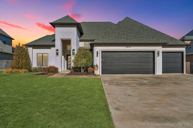 view of front of home featuring a garage and a yard