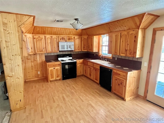 kitchen featuring wooden walls, sink, white appliances, and light wood-type flooring