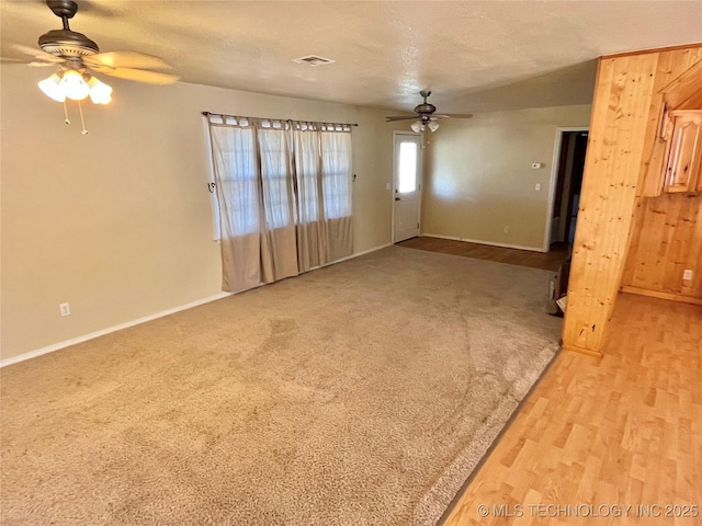 unfurnished living room featuring ceiling fan, a textured ceiling, and light hardwood / wood-style flooring