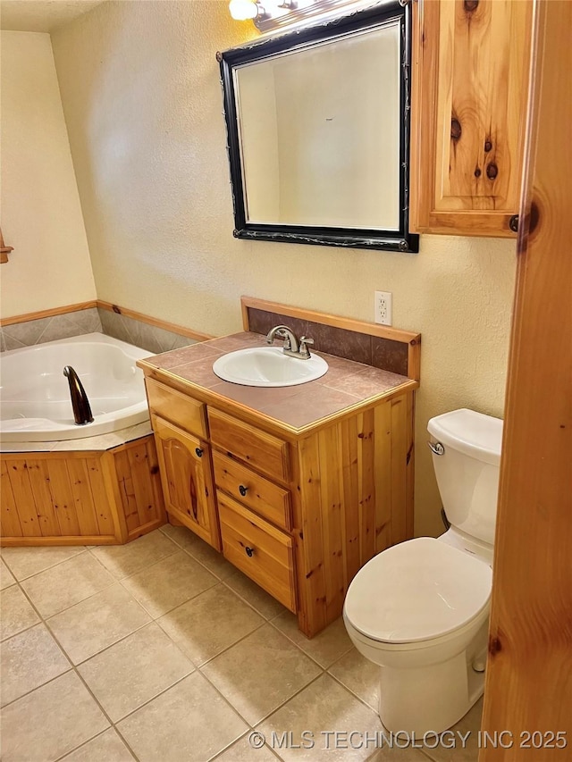 bathroom featuring tile patterned floors, vanity, toilet, and a bathing tub