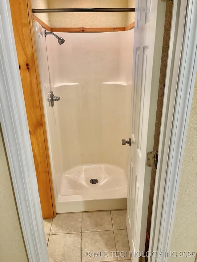 bathroom with tile patterned floors and walk in shower