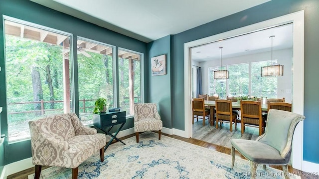 living area featuring an inviting chandelier, baseboards, and wood finished floors