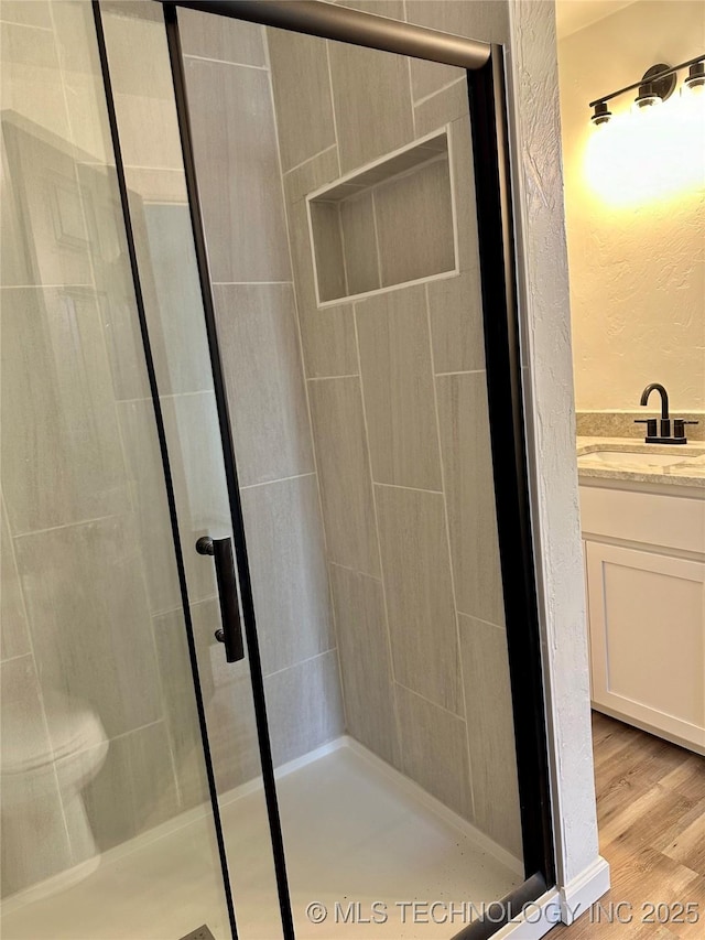 bathroom with vanity, wood-type flooring, and walk in shower