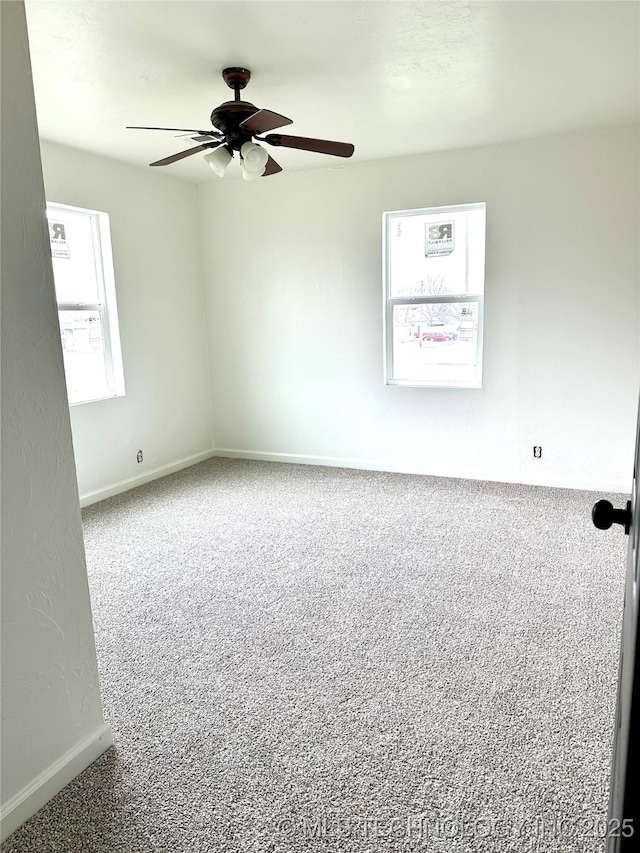 spare room featuring carpet, ceiling fan, and a healthy amount of sunlight