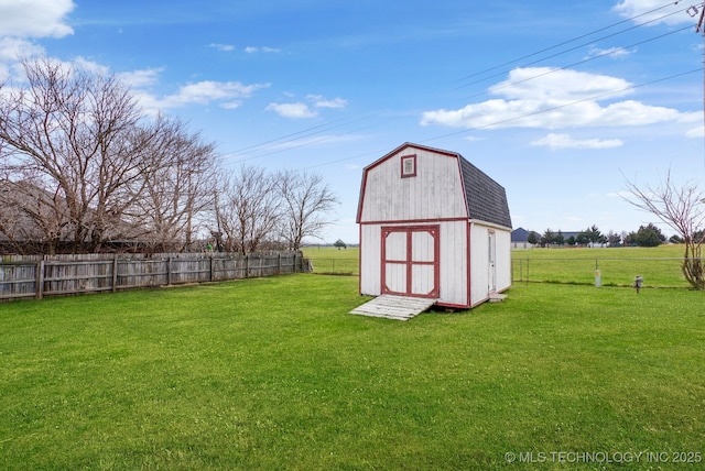 view of outbuilding featuring a rural view and a lawn