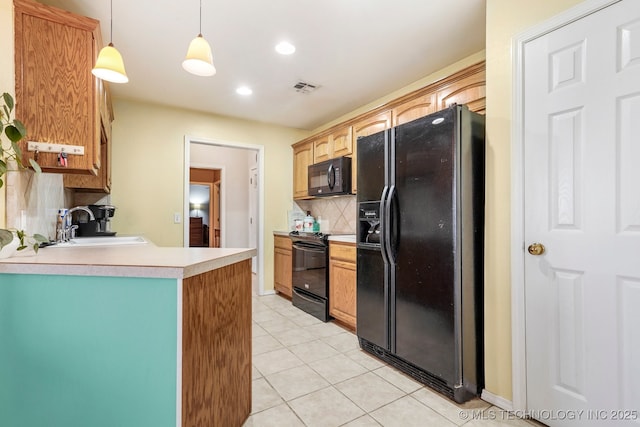 kitchen featuring sink, hanging light fixtures, tasteful backsplash, light tile patterned floors, and black appliances