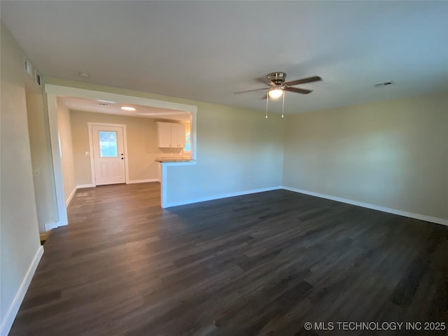 unfurnished living room featuring ceiling fan and dark hardwood / wood-style flooring